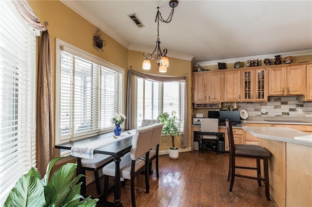 kitchen featuring hanging light fixtures, dark wood-type flooring, an inviting chandelier, backsplash, and crown molding