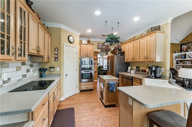 kitchen featuring a center island, a kitchen breakfast bar, sink, light wood-type flooring, and stainless steel appliances