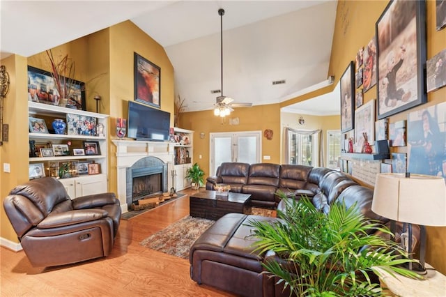 living room with ceiling fan, lofted ceiling, and light hardwood / wood-style flooring