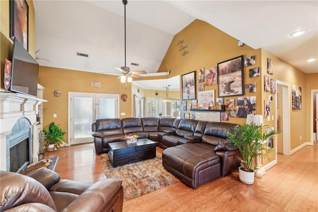 living room featuring light hardwood / wood-style floors, vaulted ceiling, and ceiling fan