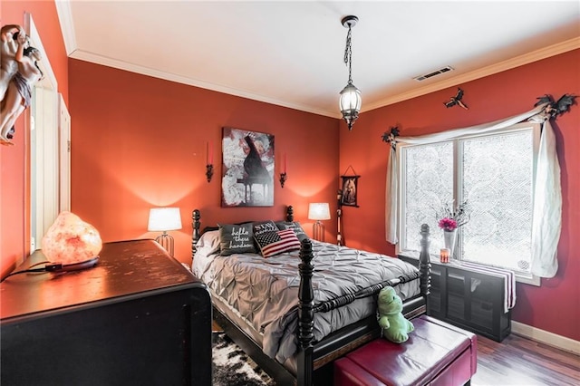 bedroom featuring hardwood / wood-style floors and crown molding