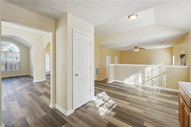 hallway with a textured ceiling and dark hardwood / wood-style flooring