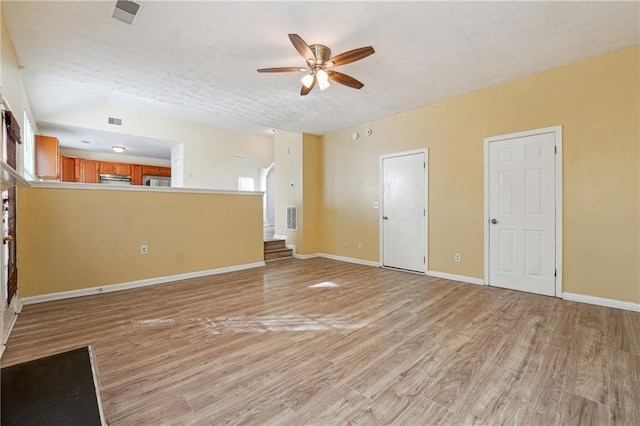 unfurnished living room with ceiling fan, a textured ceiling, and light wood-type flooring