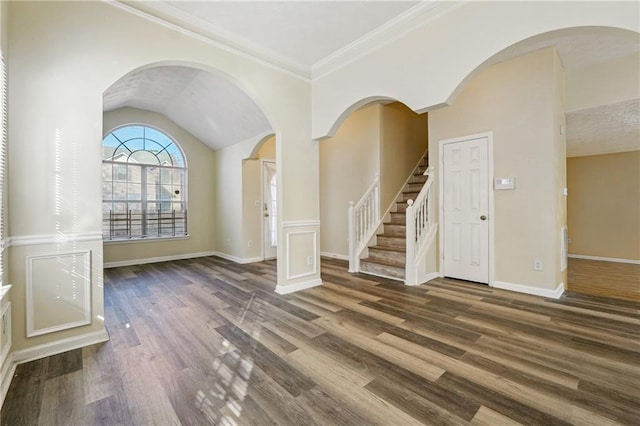 unfurnished living room featuring vaulted ceiling, dark wood-type flooring, and crown molding