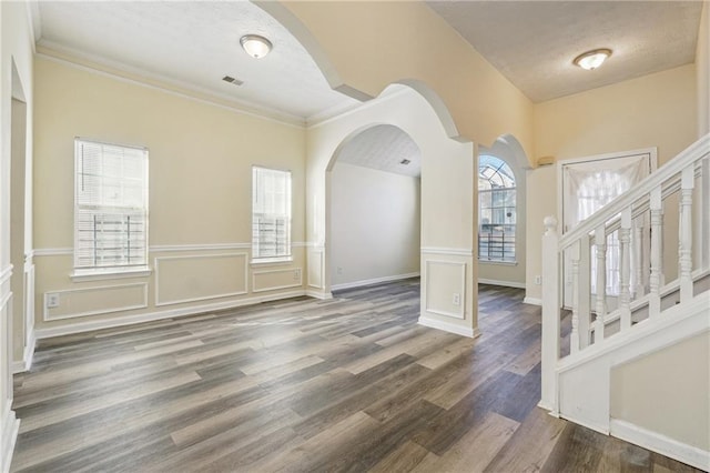 entrance foyer featuring dark wood-type flooring, a textured ceiling, and crown molding