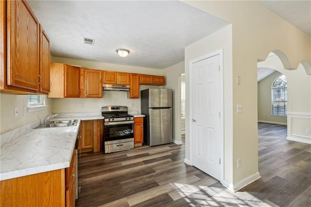 kitchen with sink, a textured ceiling, dark hardwood / wood-style floors, and stainless steel appliances