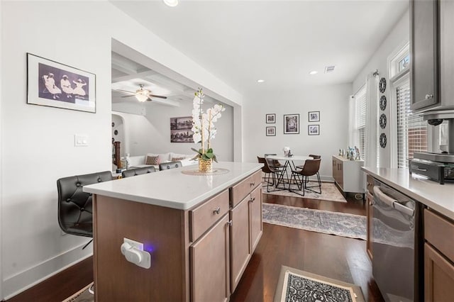 kitchen featuring ceiling fan, beamed ceiling, dishwasher, dark hardwood / wood-style floors, and a kitchen island