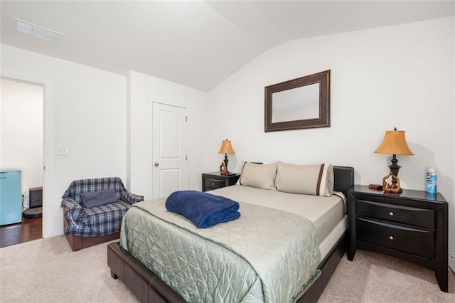 bedroom featuring lofted ceiling and light carpet