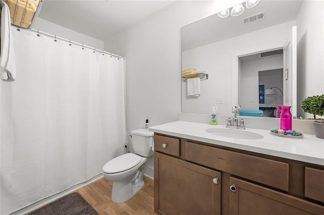 bathroom with vanity, hardwood / wood-style flooring, and toilet