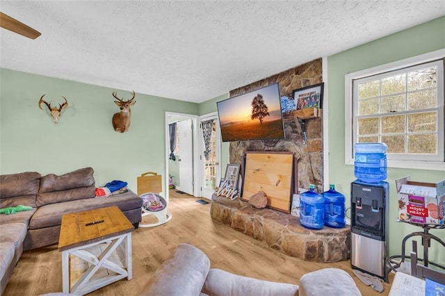 living room with a textured ceiling and light wood-type flooring