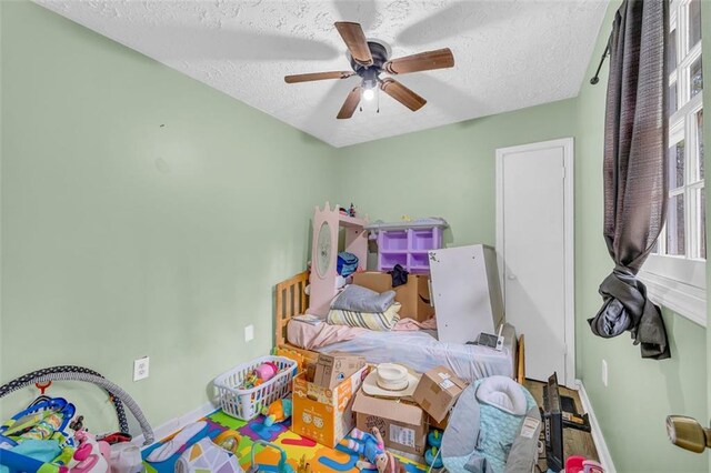 bedroom with ceiling fan and a textured ceiling