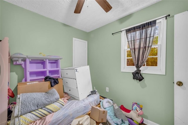 bedroom featuring ceiling fan and a textured ceiling