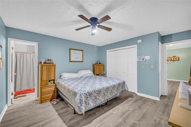 bedroom featuring ceiling fan, light hardwood / wood-style floors, a closet, and a textured ceiling