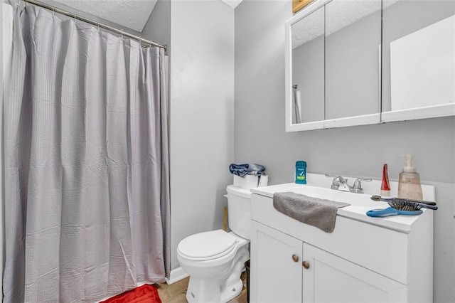 bathroom featuring vanity, a textured ceiling, and toilet