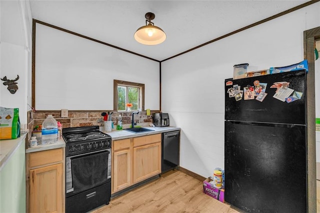 kitchen featuring sink, black appliances, crown molding, light brown cabinets, and light wood-type flooring