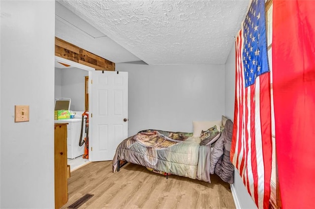 bedroom with hardwood / wood-style flooring and a textured ceiling