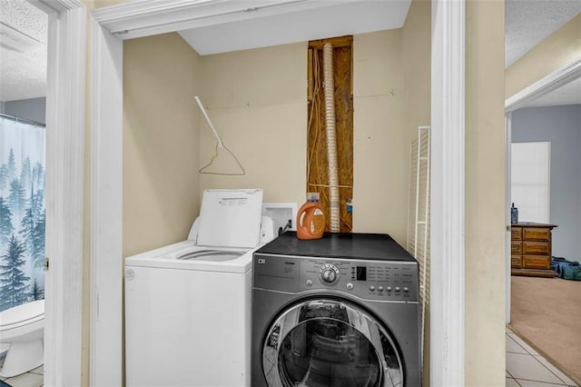 laundry room with washing machine and dryer and light tile patterned floors