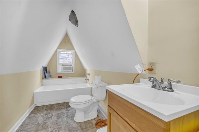 bathroom with vanity, lofted ceiling, a bathtub, and toilet