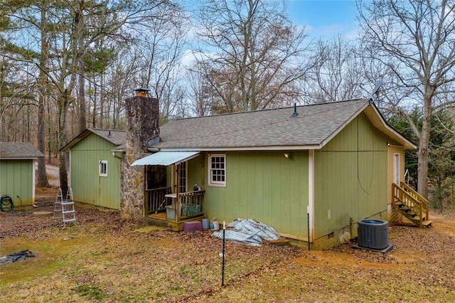 rear view of house with central AC and a storage unit