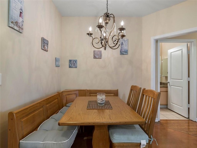 tiled dining room featuring a chandelier