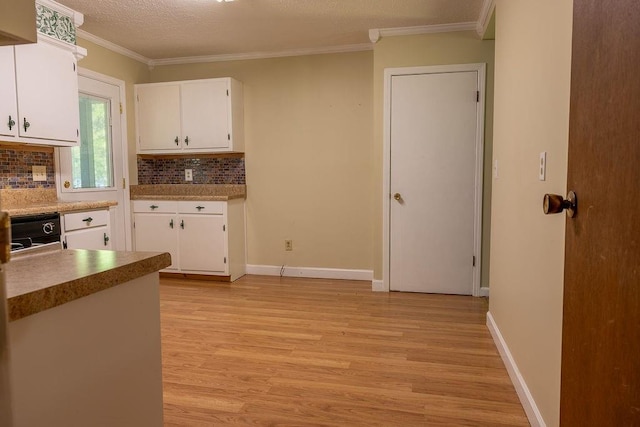 4370 Tradition Ter, Austell, GA 30106 - kitchen with light wood-type flooring, backsplash, white cabinetry, crown molding, and baseboards