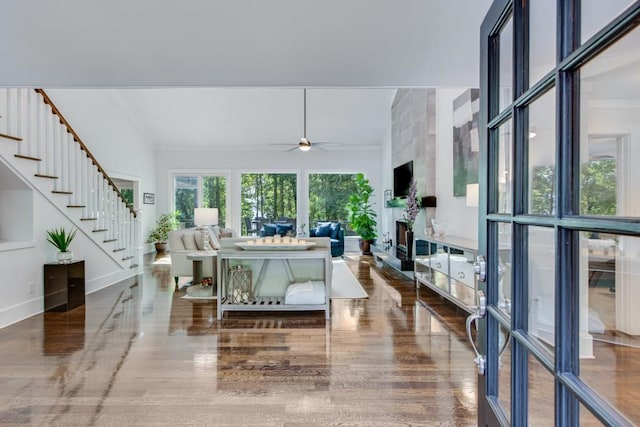 6144 Scott Dr, Flowery Branch, GA 30542 - living room featuring stairway, wood finished floors, a ceiling fan, a fireplace, and ornamental molding
