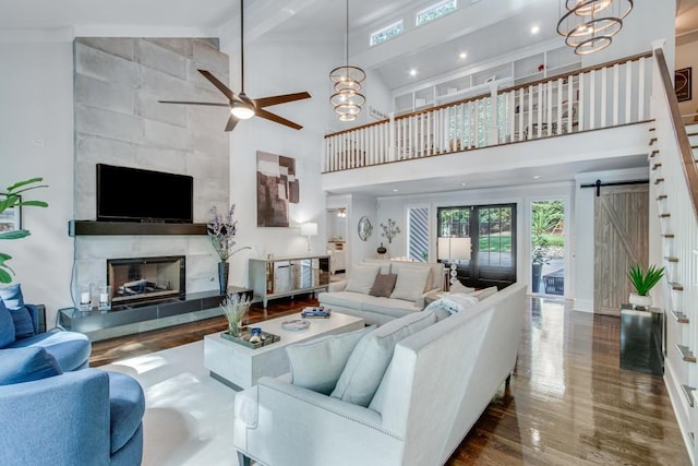 6144 Scott Dr, Flowery Branch, GA 30542 - living area with a high ceiling, a ceiling fan, wood finished floors, a fireplace, and baseboards