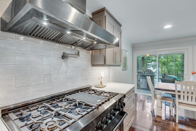 6144 Scott Dr, Flowery Branch, GA 30542 - kitchen with high end stove, wall chimney range hood, backsplash, crown molding, and dark wood-type flooring