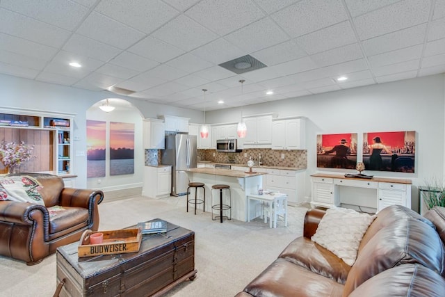 6144 Scott Dr, Flowery Branch, GA 30542 - living room featuring light carpet, arched walkways, and a paneled ceiling