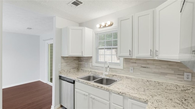 6964 Oakhill Cir, Austell, GA 30168 - kitchen with stainless steel dishwasher, a sink, wood finished floors, decorative backsplash, and a textured ceiling