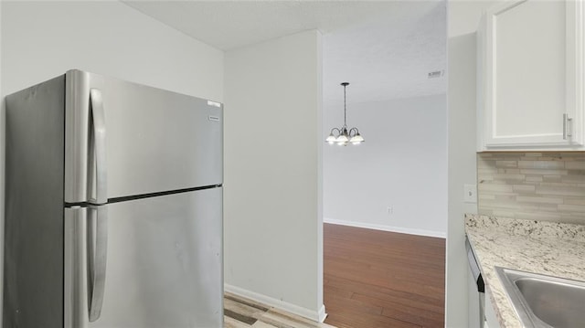 6964 Oakhill Cir, Austell, GA 30168 - kitchen featuring freestanding refrigerator, light wood-type flooring, white cabinets, a chandelier, and backsplash