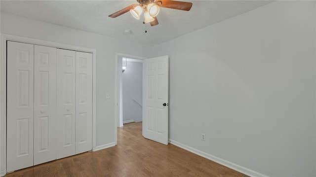 6964 Oakhill Cir, Austell, GA 30168 - unfurnished bedroom with wood finished floors, baseboards, a closet, and ceiling fan