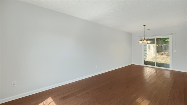 6964 Oakhill Cir, Austell, GA 30168 - spare room featuring a chandelier, dark wood-type flooring, and baseboards