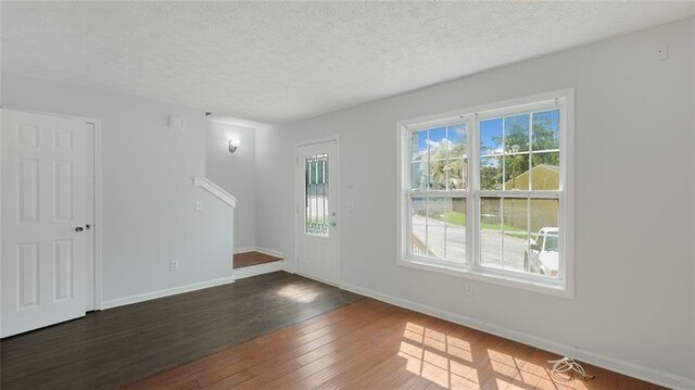 6964 Oakhill Cir, Austell, GA 30168 - unfurnished living room with baseboards, dark wood-type flooring, and a textured ceiling