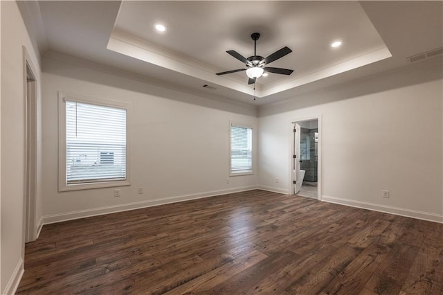 unfurnished room featuring a tray ceiling, ceiling fan, dark wood-type flooring, and ornamental molding