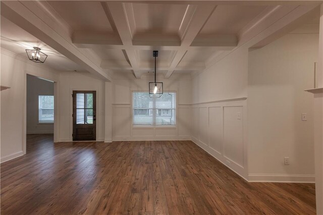 unfurnished dining area featuring beamed ceiling, dark wood-type flooring, coffered ceiling, and a notable chandelier