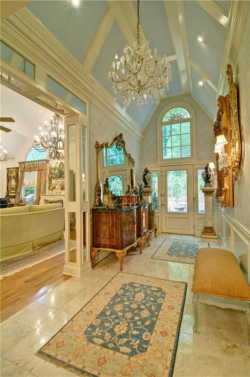 entryway featuring light wood-type flooring, crown molding, and a towering ceiling