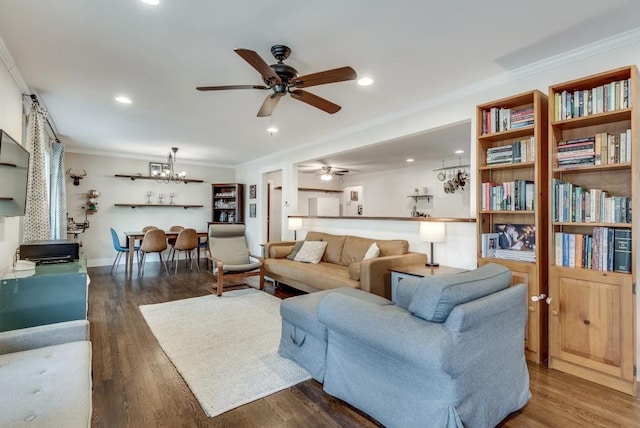 living room with ceiling fan with notable chandelier, wood finished floors, recessed lighting, crown molding, and baseboards