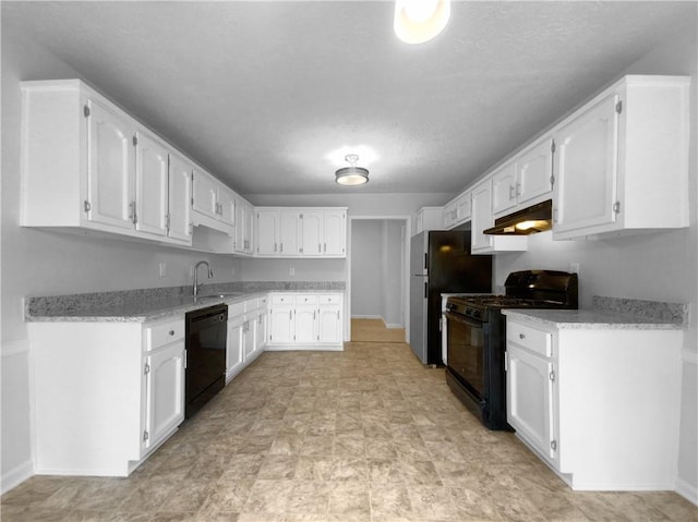 kitchen with light stone counters, white cabinets, black appliances, and sink