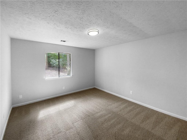 empty room featuring a textured ceiling and carpet flooring