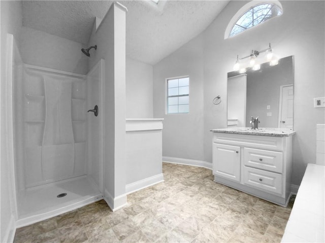 bathroom with a shower, vanity, a textured ceiling, and vaulted ceiling