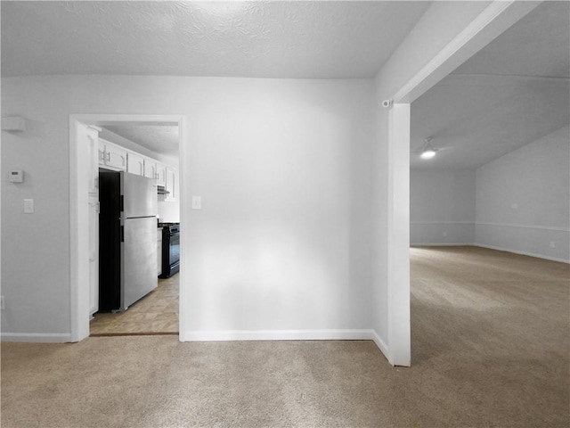 hall featuring a textured ceiling and light colored carpet