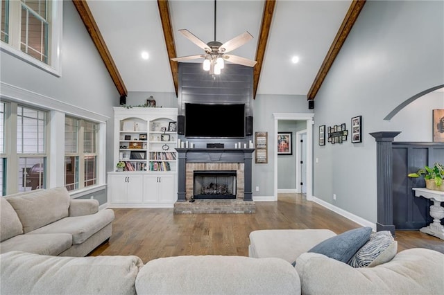7269 Tyree Rd, Winston, GA 30187 - living room featuring a fireplace, high vaulted ceiling, a ceiling fan, beam ceiling, and wood finished floors