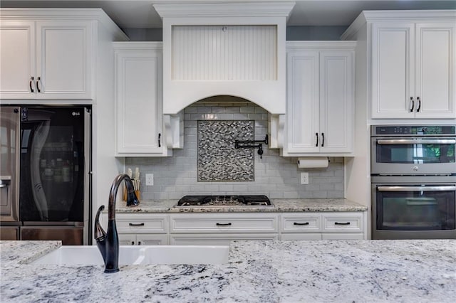7269 Tyree Rd, Winston, GA 30187 - kitchen with stainless steel appliances, white cabinetry, decorative backsplash, and light stone counters