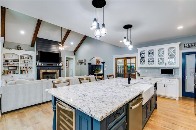 7269 Tyree Rd, Winston, GA 30187 - kitchen featuring wine cooler, stainless steel dishwasher, white cabinets, a fireplace, and decorative light fixtures