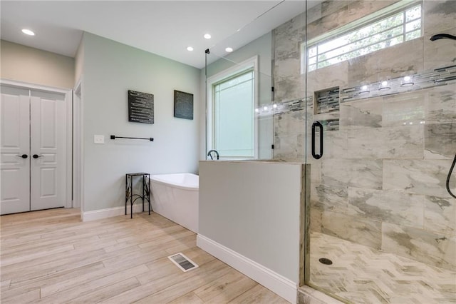 7269 Tyree Rd, Winston, GA 30187 - full bathroom featuring a freestanding bath, a stall shower, wood finished floors, and recessed lighting