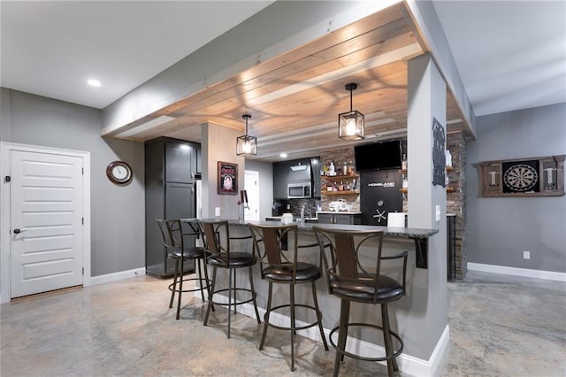 7269 Tyree Rd, Winston, GA 30187 - indoor wet bar featuring finished concrete floors, stainless steel microwave, pendant lighting, tasteful backsplash, and recessed lighting