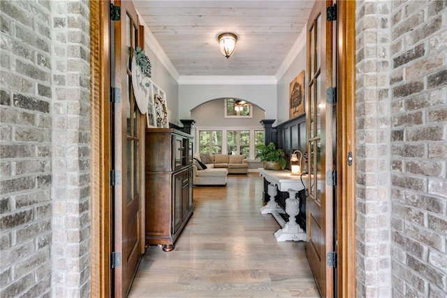 7269 Tyree Rd, Winston, GA 30187 - hall with arched walkways, light wood-style flooring, ornamental molding, and brick wall