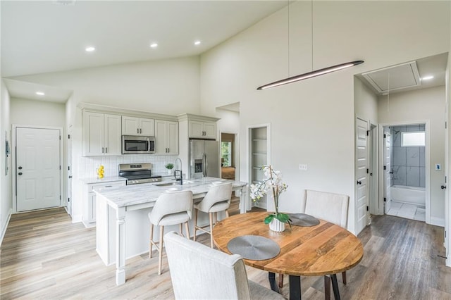 623 Hamilton E Holmes Dr NW, Atlanta, GA 30318 - dining area with attic access, light wood-style flooring, recessed lighting, and vaulted ceiling