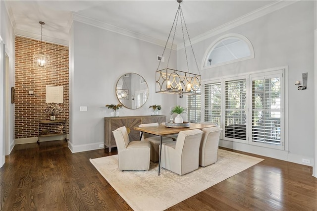 dining area featuring brick wall, ornamental molding, breakfast area, dark wood-style flooring, and a high ceiling